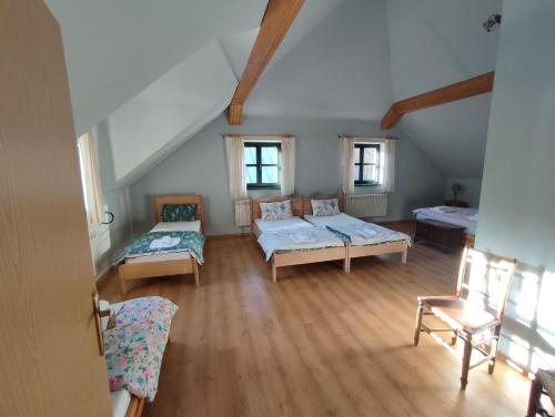 an attic room with two beds and a couch at Roztoczańska Posiadłość in Lipsko-Polesie