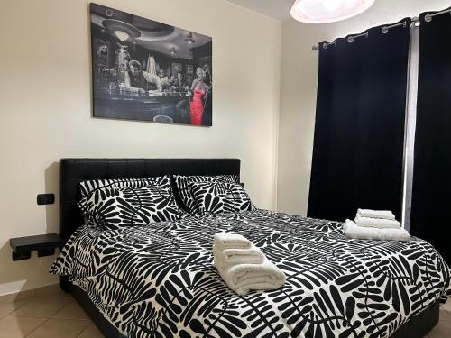 Un dormitorio con una cama en blanco y negro con toallas. en Alloggio Angelo Bovo 4, en Fiumicino