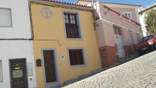 a yellow building with a clock on the side of it at Casa à Porta do Torreão in Silves
