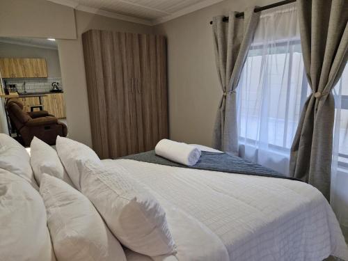 a bedroom with a bed with white pillows and a window at Levangrey in George