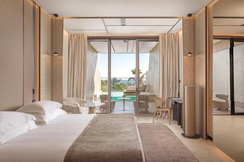 a bedroom with a bed and a living room at Amathus Beach Hotel Limassol in Limassol