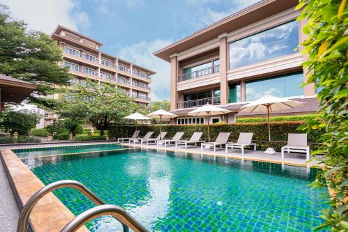a swimming pool with chairs and a building at Hillside Residence Khaoyai in Mu Si