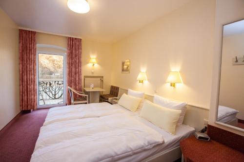 a large white bed in a room with a window at Hotel Garni Günther in Boppard