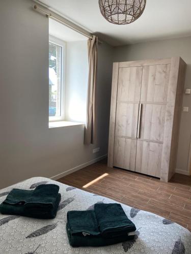 - une chambre avec un lit et 2 serviettes vertes dans l'établissement Maison au calme, à Ploëzal