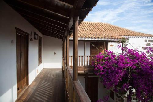 a balcony of a house with purple flowers at Rural Rugama in Puerto del Rosario