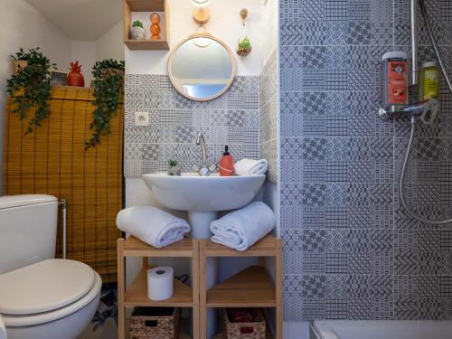 une salle de bain avec un lavabo, des toilettes et un miroir dans l'établissement BnGo I L'Élégant I Duplex Croix-Rousse vue sur Fourvière, 2 personnes, Cosy et moderne, à Lyon