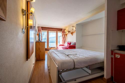 ein kleines Schlafzimmer mit einem Bett in einem Zimmer in der Unterkunft Le cosmos in Villarembert