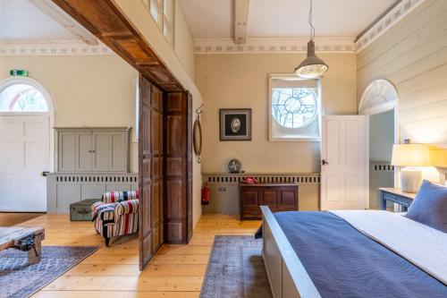 a bedroom with a bed and a living room at Belchamp Hall Stables in Belchamp Otten