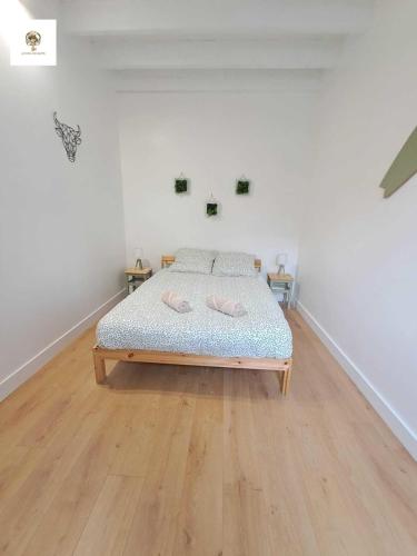 Ce lit se trouve dans un dortoir blanc doté de parquet. dans l'établissement Charmante Maisonnette Rénovée - 5 min d'Argenton Sur Creuse, à Chabenet