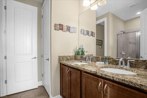 a bathroom with two sinks and a large mirror at GREAT HOUSE Near Disney, Private Pool in Orlando
