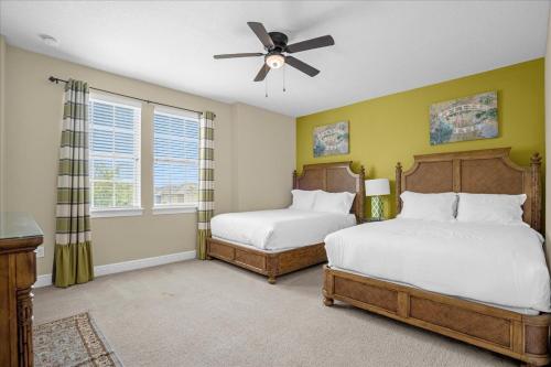 a bedroom with two beds and a ceiling fan at GREAT HOUSE Near Disney, Private Pool in Orlando