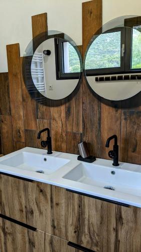une salle de bain avec deux lavabos et deux miroirs dans l'établissement Homekeeper 3 villas récentes vue mer piscine privée, à Conca