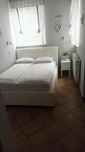 a bedroom with a white bed and a window at Wydmuchówka in Jurata