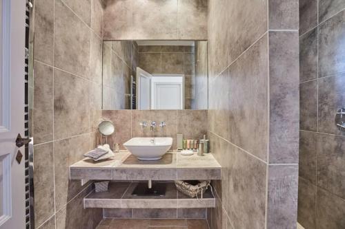 une salle de bain avec un lavabo et un miroir dans l'établissement Havre de paix à Gordes avec piscine chauffée, à Gordes