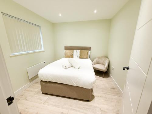 a small bedroom with a bed and a chair at 2 Bedroom Duplex's in Huntingdon - Built for Contractors & Professionals - Balcony - WiFi - Fully Equipped Kitchen - Smart TV - Ideal for Work Stays - Long Projects in Huntingdon