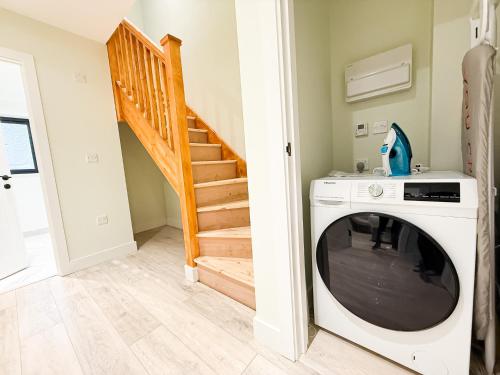 a washing machine in a room with a staircase at 2 Bedroom Duplex's in Huntingdon - Built for Contractors & Professionals - Balcony - WiFi - Fully Equipped Kitchen - Smart TV - Ideal for Work Stays - Long Projects in Huntingdon