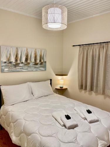 a bedroom with a large white bed with towels on it at Nennella's House in Ágios Rókkos