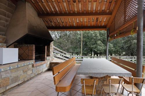 an outdoor patio with a table and chairs and a fireplace at Casanova de Noet in Aviá