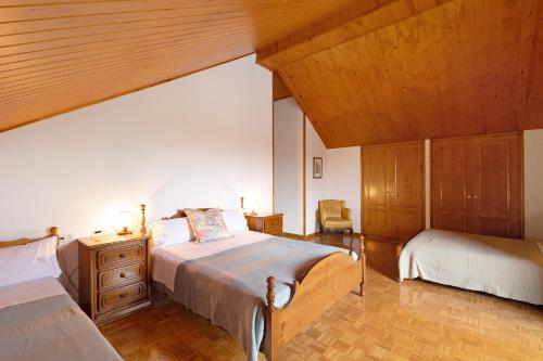 a bedroom with two beds and a wooden ceiling at Casanova de Noet in Aviá