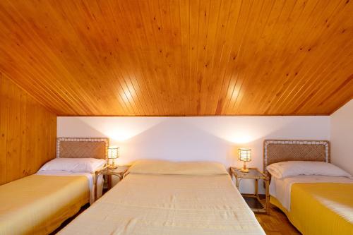 two beds in a room with wooden ceilings at Casanova de Noet in Aviá