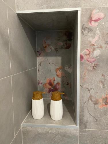 dos jarrones blancos sentados en un estante en un baño en Casa Piera, en Turín