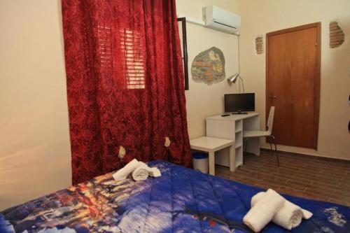 a bedroom with a bed and a desk with a computer at B&B Madema in Cefalù
