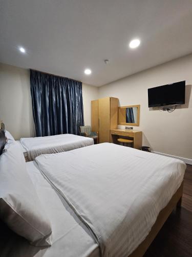 a hotel room with two beds and a flat screen tv at Cromwell Hotel in London