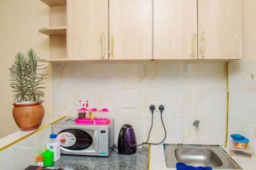 a kitchen counter with a microwave and a sink at Kirans 1 bedroom beautiful Apartment in Eldoret