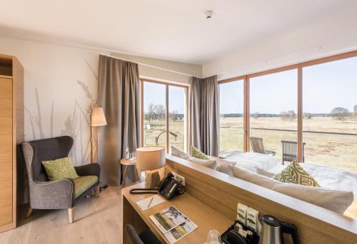 a hotel room with a bed and a desk and a chair at Hotelcamp Reinsehlen in Schneverdingen
