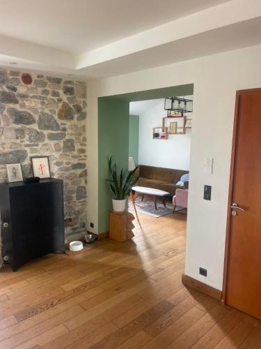 un salon avec un canapé et un mur en pierre dans l'établissement Maison mitoyenne avec jardin à Biarritz, à Arcangues