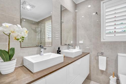 Un baño con dos lavabos y un espejo. en The Avenue at Montville, en Montville