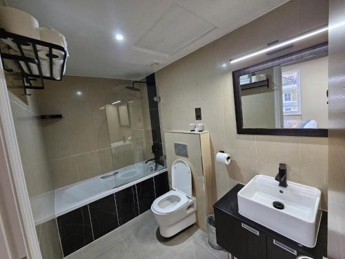 a bathroom with a sink and a toilet and a mirror at Cromwell Hotel in London