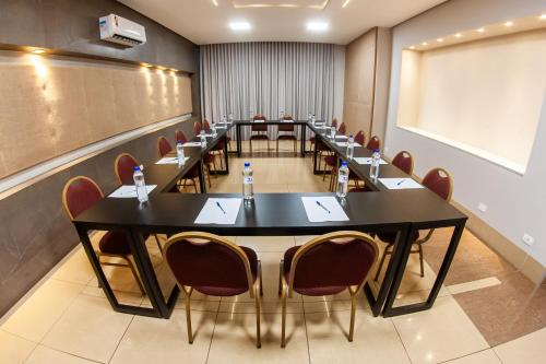 a conference room with tables and chairs and a chalkboard at London Hotel Londrina in Londrina