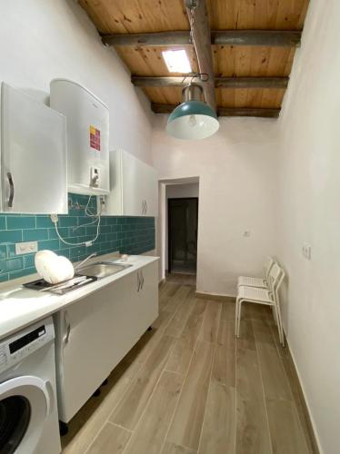 a kitchen with white cabinets and a wooden floor at Zena Houses-Casa Rural tranquila perto de Mértola in Beja