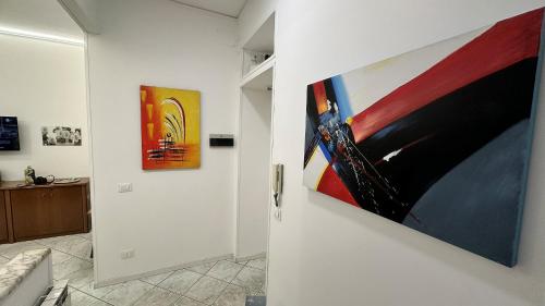 a hallway with two paintings on a wall at G&D Suite Apartment in Caltanissetta