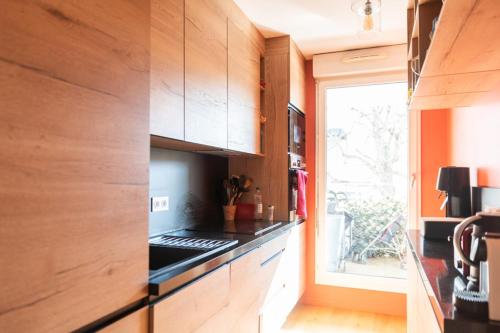 une cuisine avec des armoires en bois et un four à plaques de cuisson dans l'établissement Beautiful T3 with balcony - near park, à Boulogne-Billancourt
