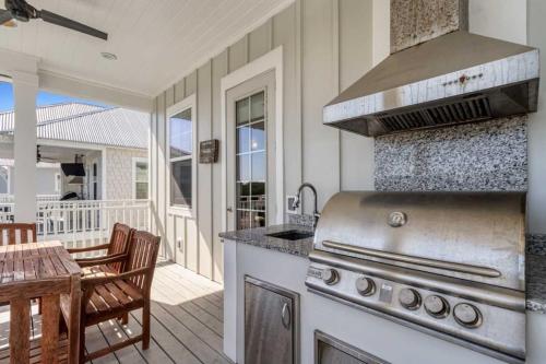a kitchen with a stove and a patio with a table at Modern Coastal Escape Near 30A - Inlet Beach in Inlet Beach