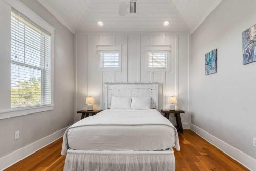 a white bedroom with a bed and two windows at Modern Coastal Escape Near 30A - Inlet Beach in Inlet Beach