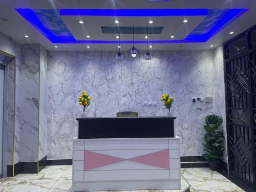 a lobby with a reception desk and a blue ceiling at Gombe243 in Kinshasa