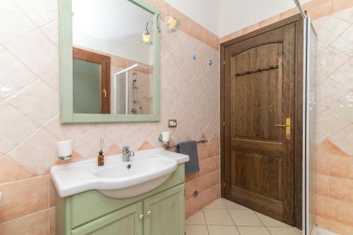 a bathroom with a sink and a mirror and a door at Casa Bouganville in Posada
