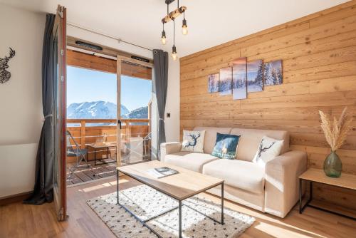 un salon avec un canapé et une table dans l'établissement Apartment Borealis, Alpe d Huez - by EMERALD STAY, à Huez