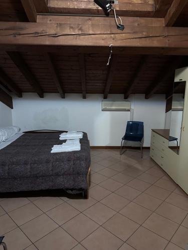 a bedroom with a bed and a blue chair at Dante 10 Flat in Cremona