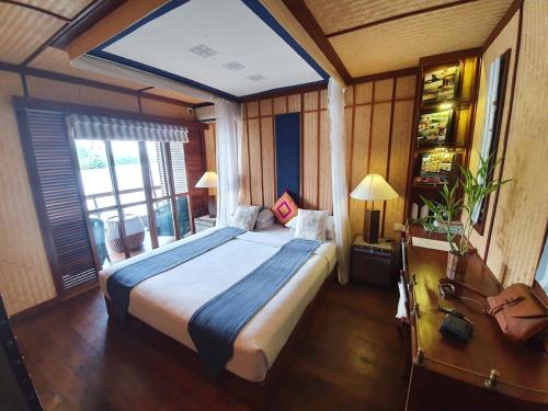 a bedroom with a large bed and a large window at Yathra Houseboat in Bentota