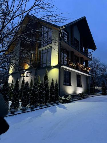 a house with christmas decorations on the balcony in the snow at Girske Povitria 2 in Yaremche