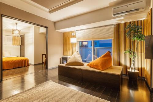 a living room with a couch and a bed at Cozy Stay Sapporo Hongodori 1005 in Sapporo