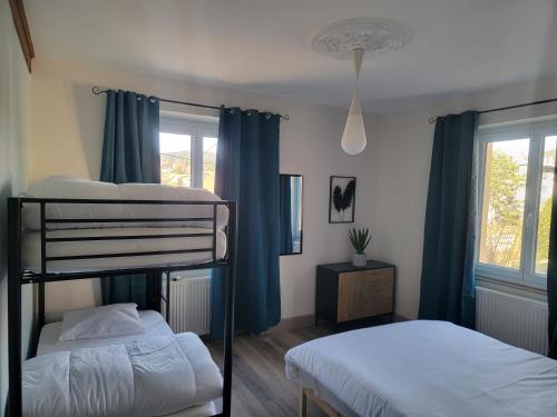 - 2 lits superposés dans une chambre dotée de rideaux bleus dans l'établissement Chez Carine et Jonathan, à Gérardmer