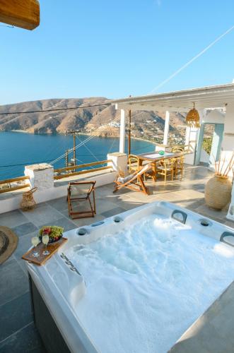 a hot tub on a deck with a view of the ocean at Idothea guest house in Amorgos