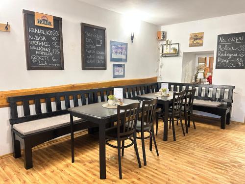 a restaurant with black tables and chairs and a chalkboard at Restaurace a penzion Na Stráni in Klášterec nad Orlicí