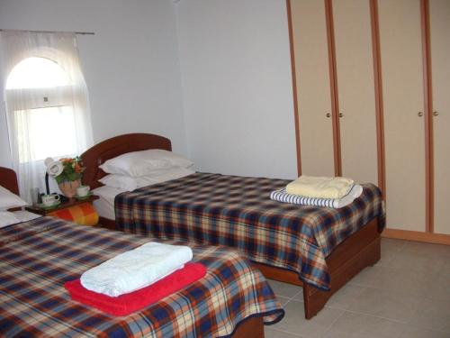 ザキントスにあるKaminia Villasのベッドルーム1室(ベッド2台、窓付)