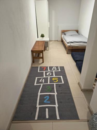 a hallway with a rug on the floor with a bed at Górska Kryjówka in Nowy Targ